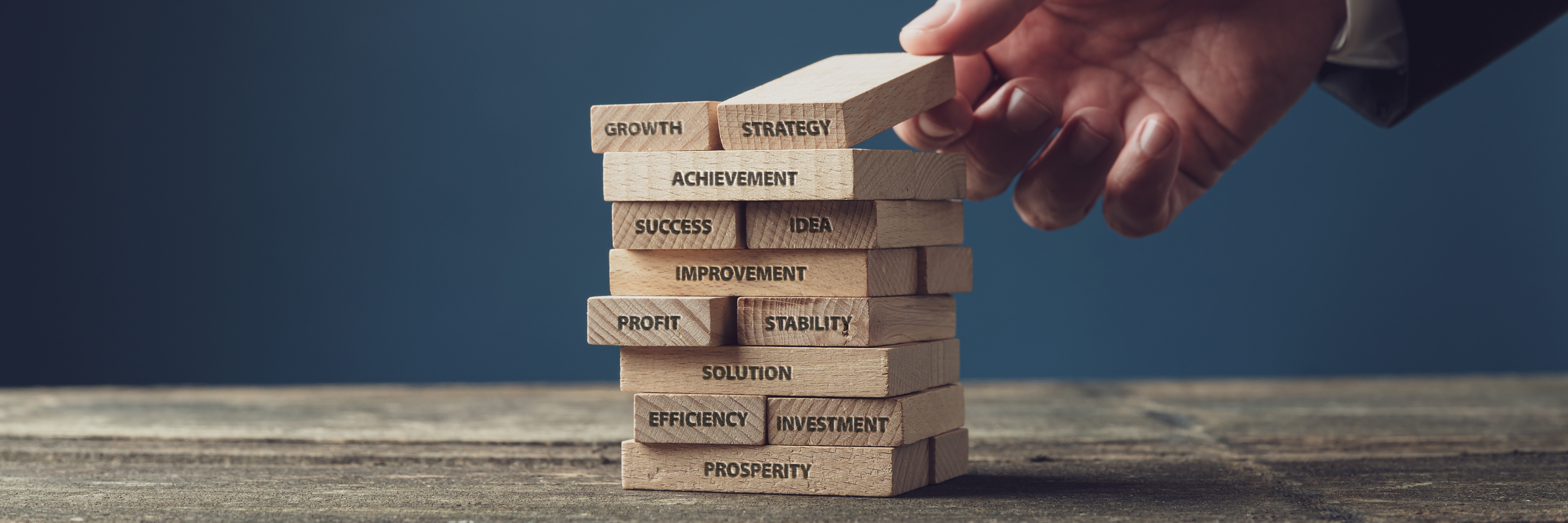 stack of wooden blocks like jenga with words about business success such as profit, improvement and strategy representative of SEO and optimisation 